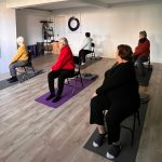 adultes en train de faire du yoga sur chaise