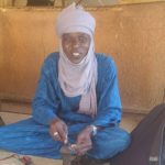 artisans touareg en train de travailler sur un bijoux assis par terre